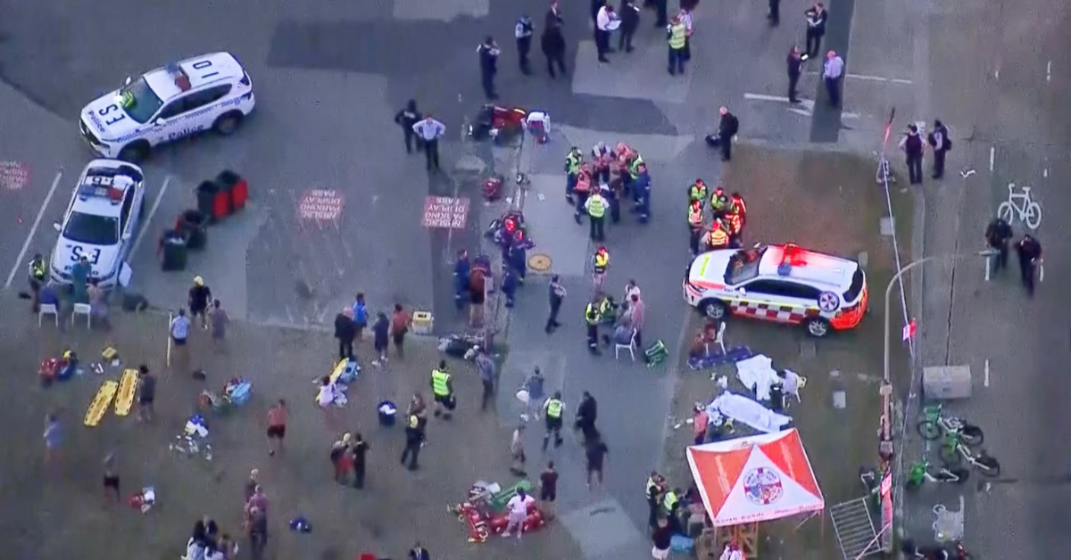 घायल व्यक्ति को आपातकालीन चिकित्सा कर्मचारियों द्वारा इलाज के दौरान स्ट्रेचर पर लाया गया। Shooting at Bondi Beach