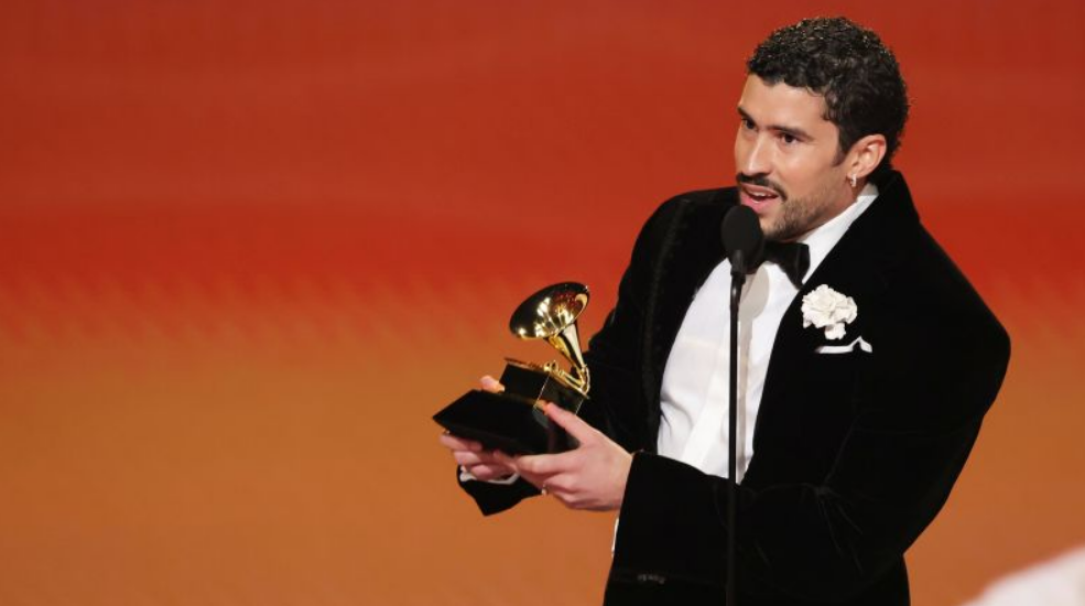 Grammy 2026 में Bad Bunny Album of the Year अवॉर्ड जीतते हुए स्टेज पर ट्रॉफी पकड़े