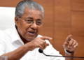 केरल के मुख्यमंत्री पिनाराई विजयन हाथ उठाकर भाषण देते हुए - Kerala Name Change प्रस्ताव लाने वाले नेता, Keralam मंजूरी पर प्रतिक्रिया
