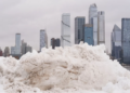 न्यूयॉर्क शहर की स्काईलाइन पर भारी बर्फ के ढेर, मैनहट्टन के पीछे skyscrapers बर्फ से ढके – 2026 snowstorm का खूबसूरत लेकिन खतरनाक नजारा। new york flights cancelled