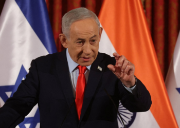 बेंजामिन नेतन्याहू इजराइली झंडों के सामने प्रेस कॉन्फ्रेंस में बोलते हुए, मार्च 2026 – Netanyahu Alive और सक्रिय दिख रहे हैं