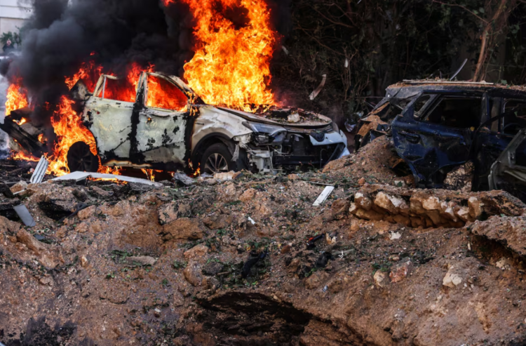 Iran Israel War Lockdown 2026 में टेल अवीव में मिसाइल हमले से लगी आग और क्षतिग्रस्त वाहन |